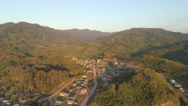 在阳光明媚的日子里，无人机在老挝湄公河附近山区的住宅建筑上向前飞行视频素材