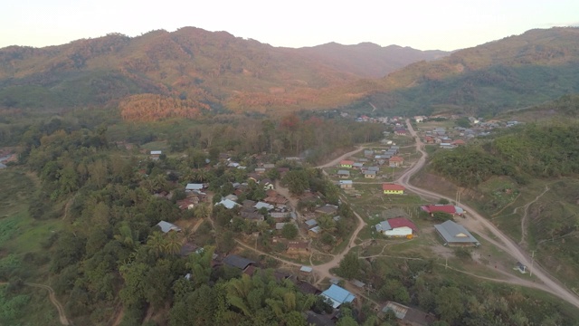 空中拍摄的房屋在树林中村庄的天空，无人机在山区周围的住宅结构上平移-湄公河，老挝视频素材