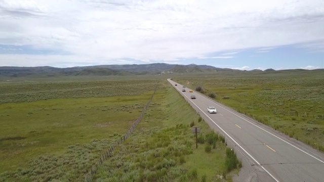 空中拍摄的车辆在乡村道路上移动的天空，无人机在绿色景观上方飞行-博伊西，爱达荷州视频素材