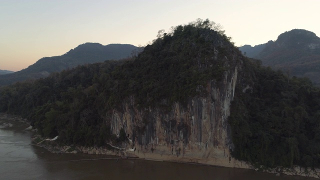 空中拍摄的树木对天空附近的河流，无人机飞行向前在日落-湄公河，老挝视频素材