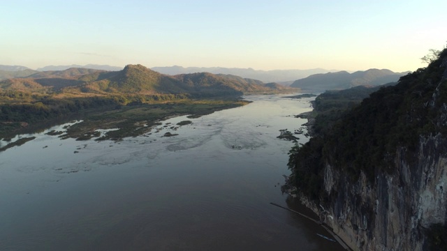 航拍:在清澈的天空下的河流风景，无人机在水面上向上移动——老挝湄公河视频素材