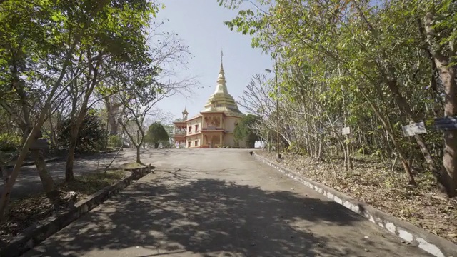 在阳光明媚的日子里，在通往寺庙的植物中间的小路的延时拍摄。老挝的琅法邦视频素材