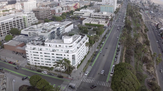 空中倾斜拍摄城市建筑附近街道上的车辆，无人机飞越城市景观——圣塔莫尼卡，加利福尼亚视频素材