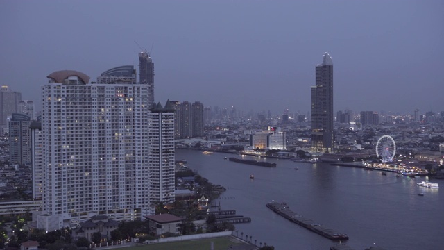 在曼谷，泰国，夜晚，天空与河流相映衬的城市灯火通明的建筑视频素材