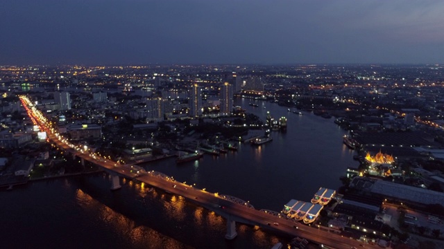 航拍的车辆在照亮的桥梁在城市的夜晚，无人机飞过城市景观对天空-曼谷，泰国视频素材