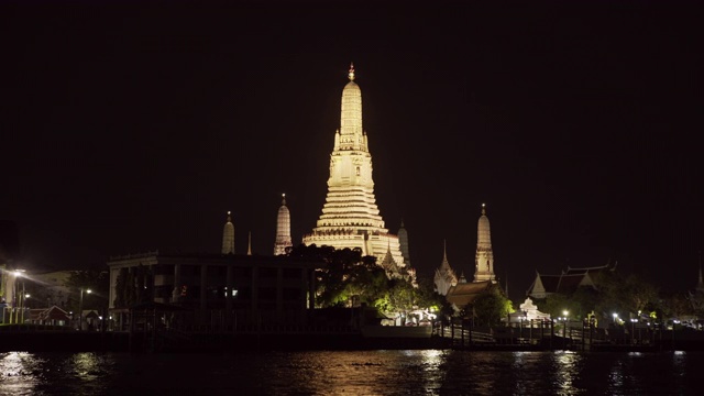 在曼谷，泰国，夜晚在天空的映衬下，在城市的河边拍摄的佛教寺庙视频素材