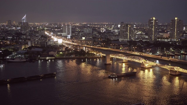 泰国曼谷，夜晚，灯火通明的高楼映衬着天空，河上大桥上的车辆被封锁的镜头视频素材