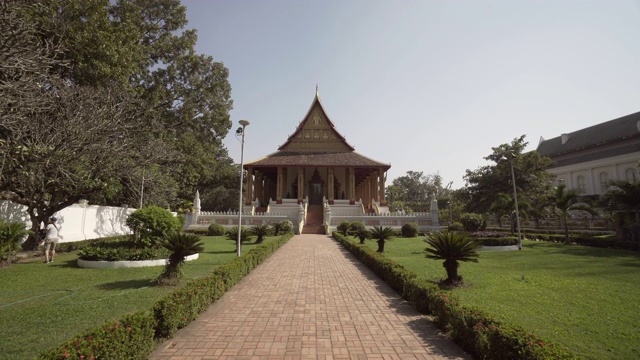 在阳光明媚的日子里，通向著名博物馆的植物中间的空人行道——老挝万象视频素材