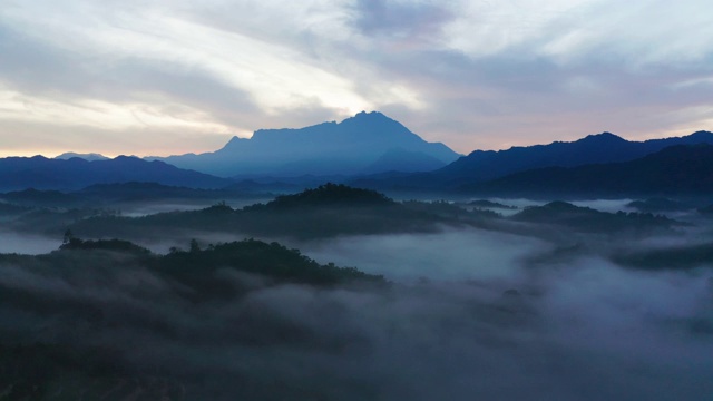 在婆罗洲沙巴州，以基纳巴卢山为背景的云雾雨林的4k镜头美丽的日出视频素材