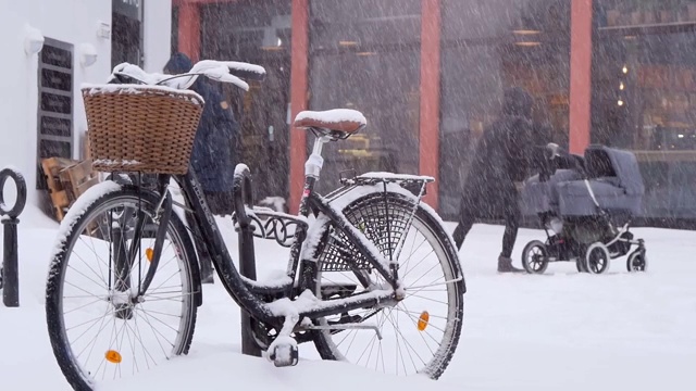 在下雪的时候，城市自行车和购物车站在街上视频素材