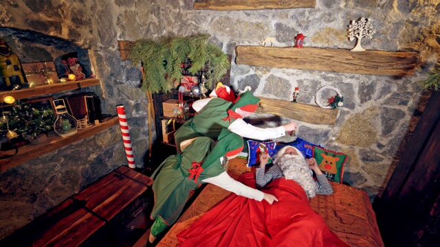 圣诞老人睡在特别装饰的房间里的床上。视频素材