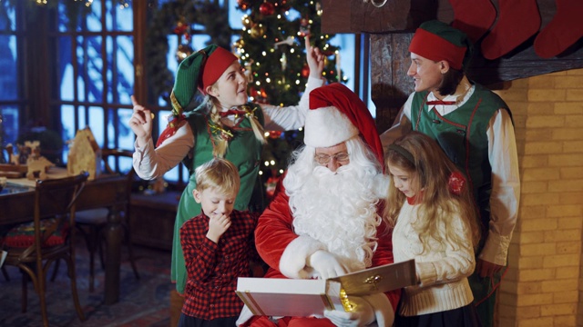 圣诞老人和孩子们和精灵们在圣诞背景上跳舞。视频素材