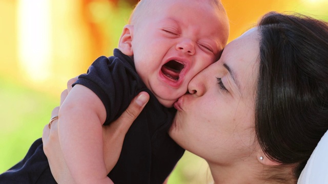 妈妈在户外安抚哭闹的婴儿，表达爱意、亲情和关心视频素材