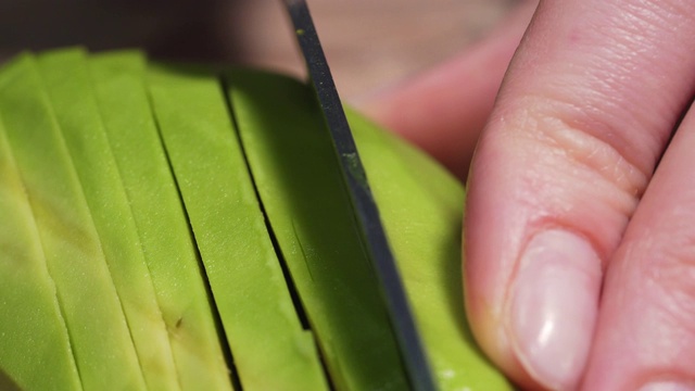 切熟牛油果的刀，静态微距拍摄4k视频素材