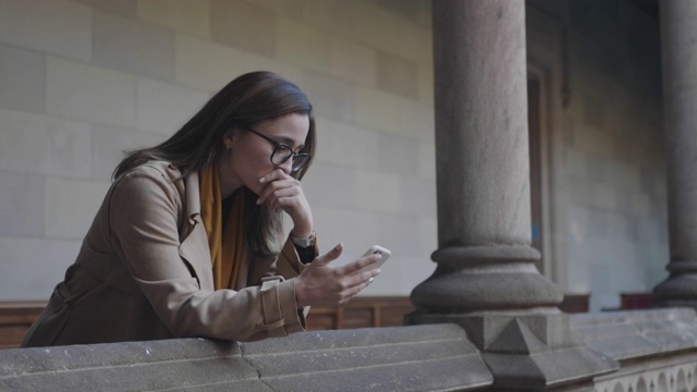 学生在手机上阅读坏消息。商业女性在户外使用智能手机视频素材