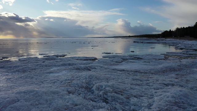 春天在海岸线上飞行，海浪上漂浮着冰块视频下载