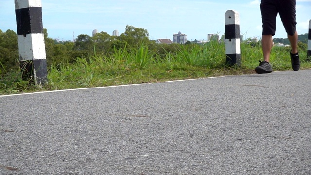 强壮的亚洲男性在户外的道路上奔跑。视频下载