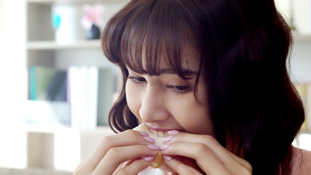 年轻女子咬着吃一个美味的大三明治视频素材
