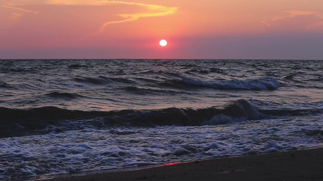 海景傍晚时分伴夕阳，海浪在海面上。视频素材