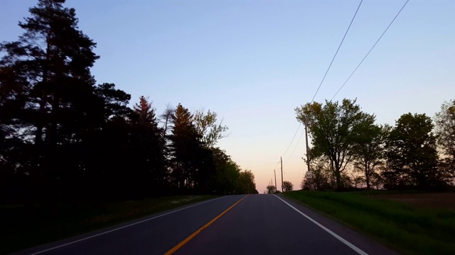 *反向运动*驾驶乡村道路在日落向后的时间流逝。司机观点POV当太阳升起在地平线上黄昏，傍晚快速度。视频素材