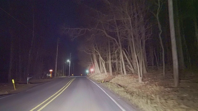 在乡村的高速公路上行驶，在夜间穿过山区的森林。视频素材