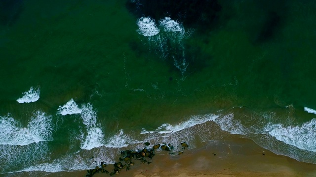 泡沫状的海浪翻滚着涌向沙滩视频素材