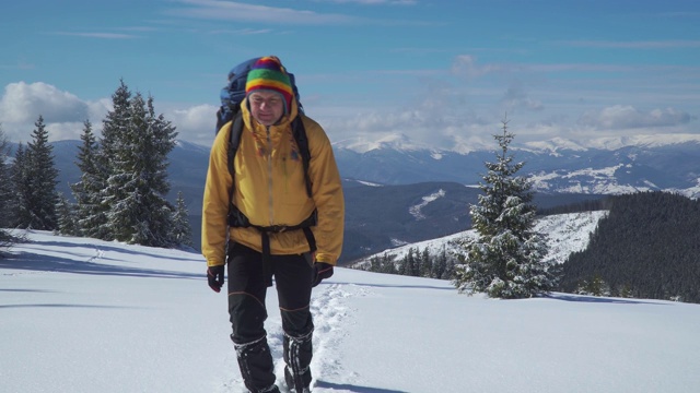 一个背着背包的男人冬天在山里旅行视频素材