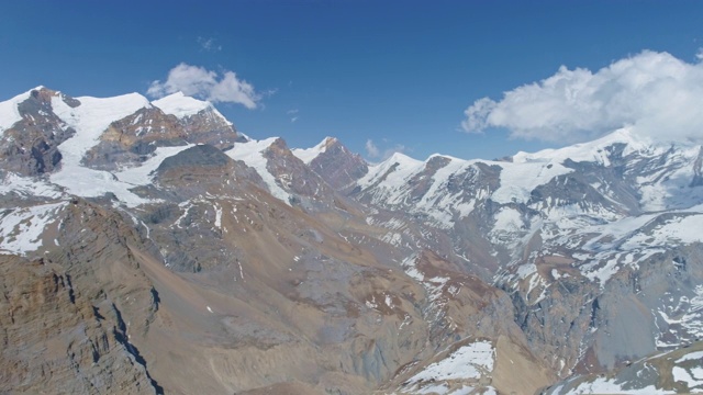 令人敬畏的高原全景，雪白色的山峰触云在蓝天视频素材