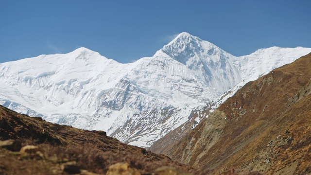 巨大的雪峰令人惊叹的安纳普尔纳山脉主宰了清澈的蓝色天空视频素材