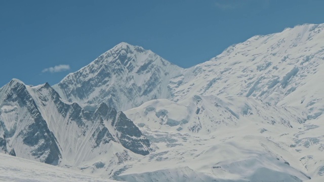 安纳布尔纳山脉的雪白色山峰在晴朗的蓝天下闪闪发光视频素材