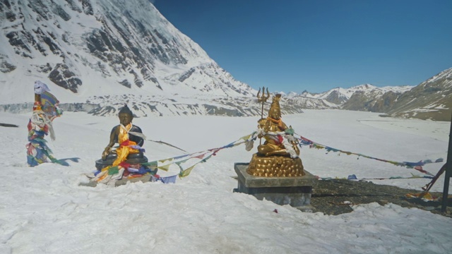 佛陀和湿婆的雕像在晴朗的蓝天下闪耀在雪山上视频素材