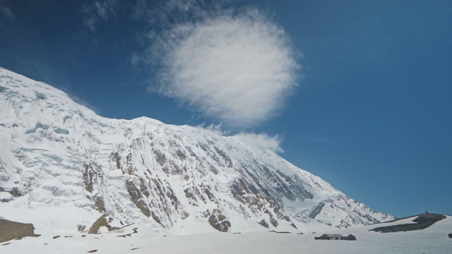 壮观的圆云盘旋在晴朗的蓝天之上，雪山山顶，全景视频素材