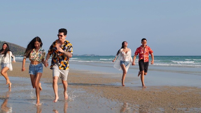 亚洲十几岁的男孩和女孩快乐地在海边海滩夏天跑步。年轻的亚洲玩跑步乐趣和周年庆典。4K分辨率和慢镜头。视频素材