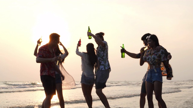 亚洲朋友庆祝快乐，在海滩上喝啤酒旅行。旅行者年轻人一起打碎啤酒瓶。朋友们一起喝混合酒精和啤酒。4K超高清慢动作。视频素材