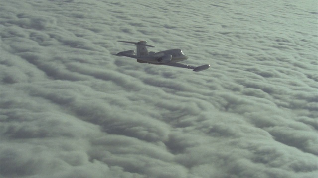 航空/白色带红色条纹的李尔喷气机/ r-l pan /空对空/云上升/飞机尖端进出/私人公司飞机视频素材