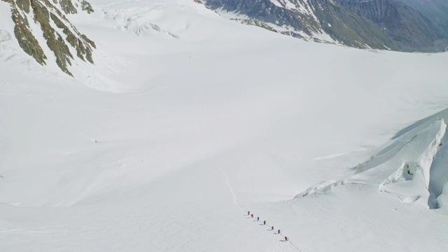 游客在空中飞翔，爬上宽敞的雪坡，登山探险视频素材