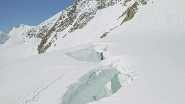 阿尔卑斯山全景，深深的塌陷在厚厚的积雪下的巨大山脚下的洼地视频素材