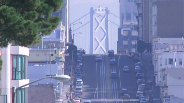 圣弗朗西斯科市的街道与奥克兰海湾大桥的bg缆车或电车在街道上出现，并直接沿街道的缆车作一站上车乘客视频素材