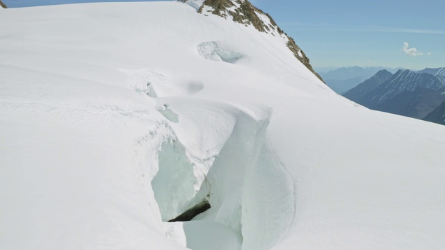 高地积雪密集，有崩塌危险，山坡边缘雪裂视频素材