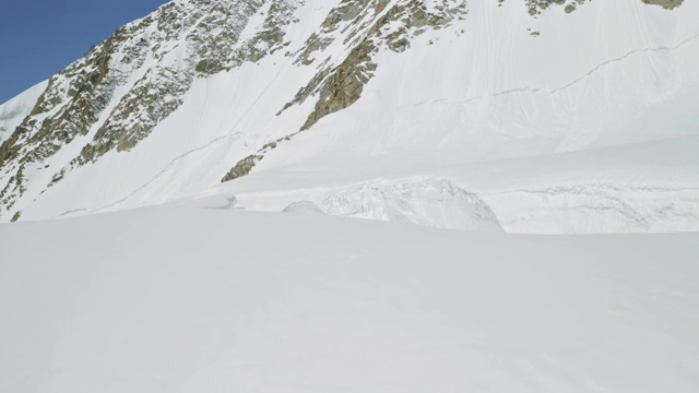 巨大的塌陷空洞在厚厚的积雪中，山上有雪崩的危险视频素材