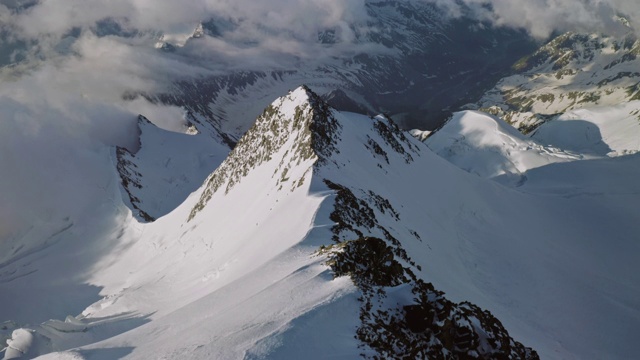 令人敬畏的高原全景云中，攀登者登上雪山之巅视频素材