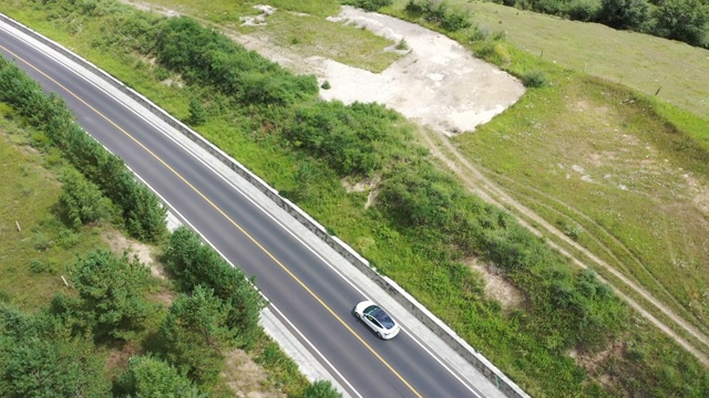 4K交通鸟瞰图白色汽车行驶在乡村道路上视频素材