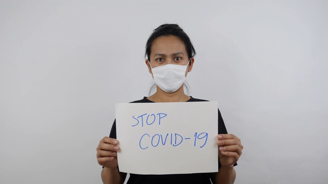 拿着STOP COVID-19标签的亚洲妇女视频素材