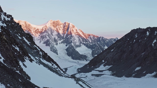 空中全景图，粉红色晨曦中的黑暗雪山视频素材