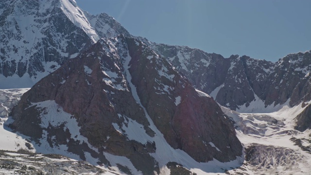 令人惊叹的高山风光，岩石山在蓝天，雪和冰川闪耀视频素材