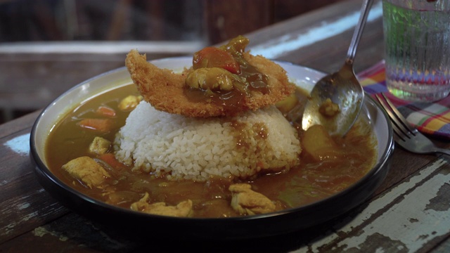 日本料理:日式蒸饭上的猪排配咖喱。干净的食物的概念。健美的形象。选择性的焦点和自由空间的文本。餐厅光线很暗。视频素材