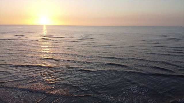 太阳落山时，一架无人机飞过海面视频素材