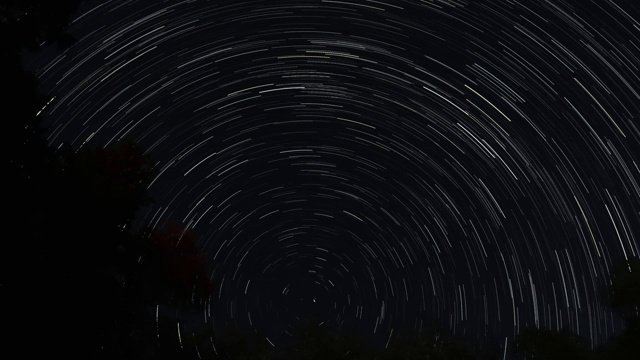 星象在威斯康辛州黑暗夜空中累积或连续的星迹时间间隔，星星围绕中心点形成一个圆形图案。视频素材