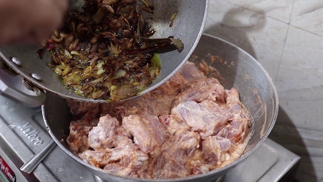 煮印度香饭时，在生鸡肉中加入炸洋葱。视频素材