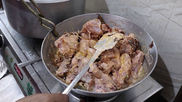 在厨房准备印度香鸡肉汁时，用炸洋葱炒生鸡肉。视频素材